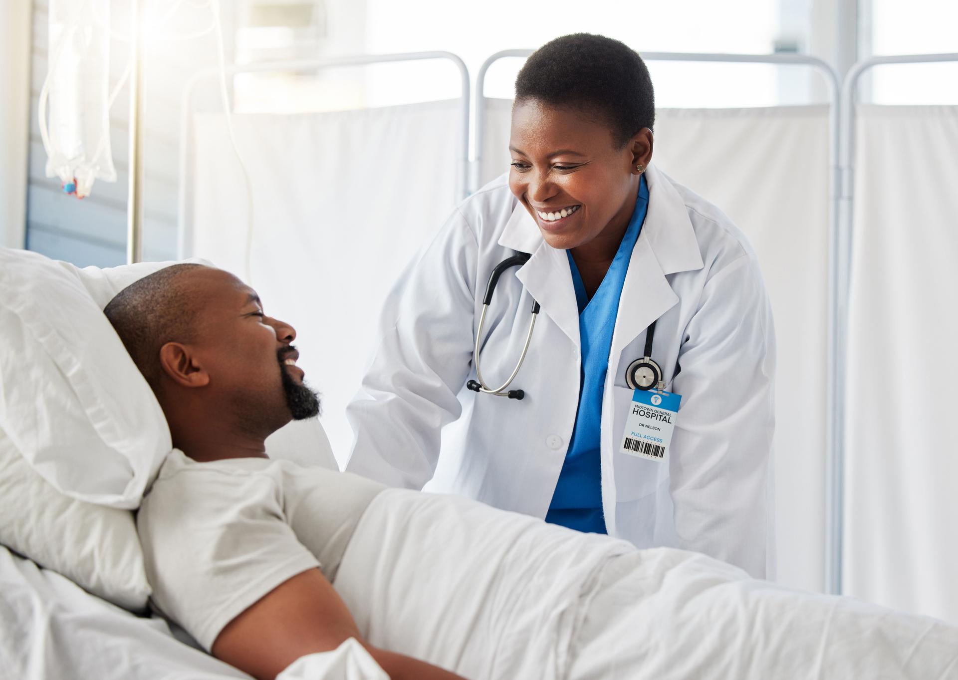 Healthcare doctor, insurance, and patient in bed talking of medical health surgery in hospital or clinic. Trust, care and help checkup by a happy, woman cardiologist worker consulting a sick person