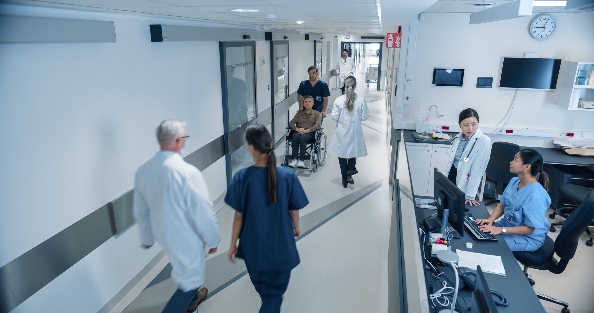 High Angle CCTV Shot with a Busy Hallway with Reception Desk of a Hospital Building, Diverse Female and Male Staff Members Walking, Working. Professional Nurses, Doctors and Personnel at Work